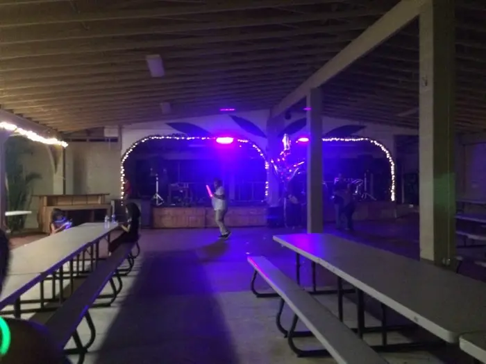 The stage wall at night with arched openings outlined in white fairy lights and purple stage lights